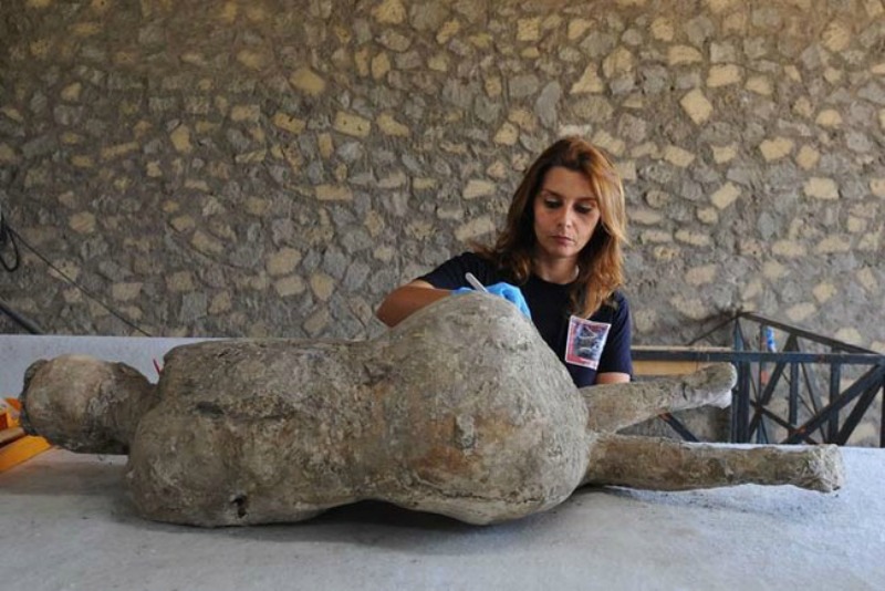 A restorer cleans and analyses a petrified victim of the eruption of Vesuvius volcano in 79 BC, as part of the restoration work and the study of 86 casts in the laboratory of Pompeii Archaeological Site, on May 20, 2015 in Pompeii. AFP PHOTO / MARIO LAPORTA (Photo credit should read MARIO LAPORTA/AFP/Getty Images)