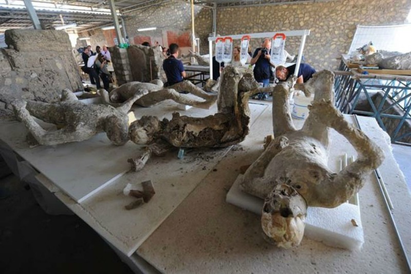 Restorers work on petrified victims of the eruption of Vesuvius volcano in 79 BC, as part of the restoration work and the study of 86 casts in the laboratory of Pompeii Archaeological Site, on May 20, 2015 in Pompeii. AFP PHOTO / MARIO LAPORTA (Photo credit should read MARIO LAPORTA/AFP/Getty Images)