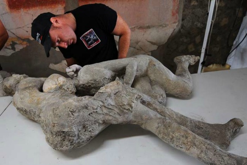 A restorer works on a petrified victim of the eruption of Vesuvius volcano in 79 BC, as part of the restoration work and the study of 86 casts in the laboratory of Pompeii Archaeological Site, on May 20, 2015 in Pompeii. AFP PHOTO / MARIO LAPORTA (Photo credit should read MARIO LAPORTA/AFP/Getty Images)