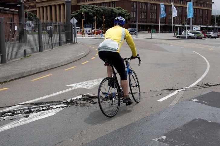 A cyclist rides over a damage road on the Wellington water front after a 7.8 earthquake centred in the South Island, in Wellington on November 14, 2016. Rescuers in New Zealand were scrambling Monday to reach the epicentre of a powerful 7.8 earthquake that killed at least two people and sparked a tsunami alert that sent thousands fleeing for higher ground. / AFP PHOTO / Marty MelvilleMARTY MELVILLE/AFP/Getty Images