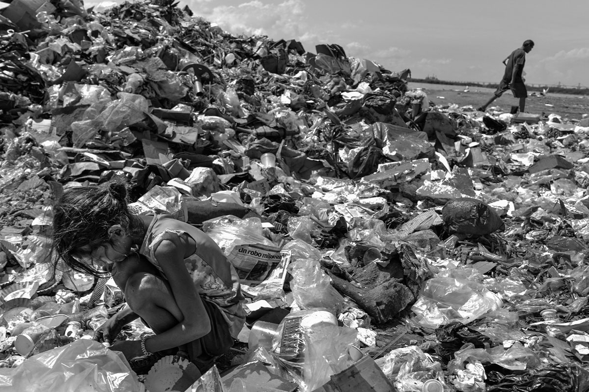 Una niña escarba entre la basura del mercado de La Pulga's, Maracaibo.