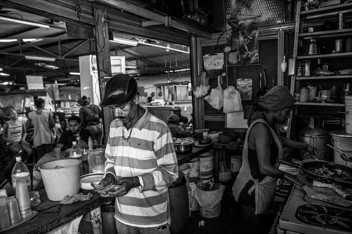 El propietario de un restaurante cuenta el dinero ganado en la jornada.