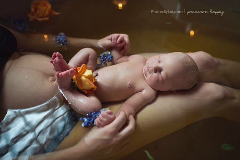 Baby and mother enjoying a fresh floral bath with soothing herbs. You can also see the mother's fresh post partum belly in this picture.