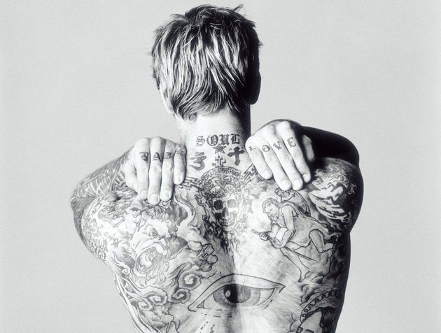 Man with tattoos on back and arms, rear view (B&W)